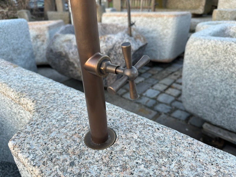 Halbrunder Granitbrunnen mit Wassereinlauf und Handrad