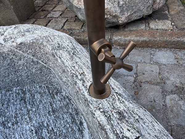 Findlingsbrunnen Schweiz Wassereinlauf mit Handrad