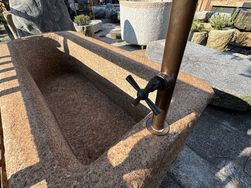 Steinbrunnen Österreich mit Wasserhahn und Handrad