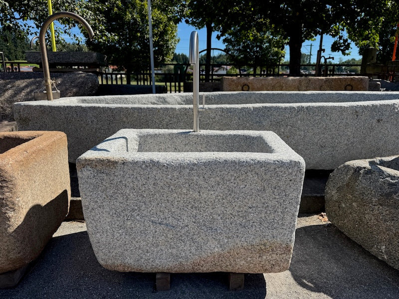 Steinbrunnen outdoor mit Wasserauslauf