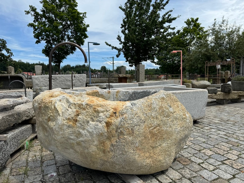 Findlingsbrunnen grau mit schwarzen Einschlüssen