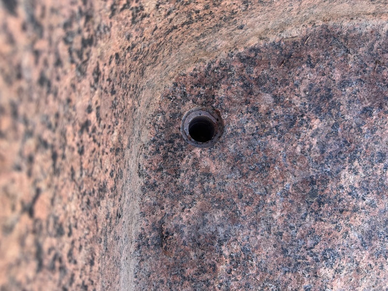 Großer roter Findlingsbrunnen Wasserauslauf