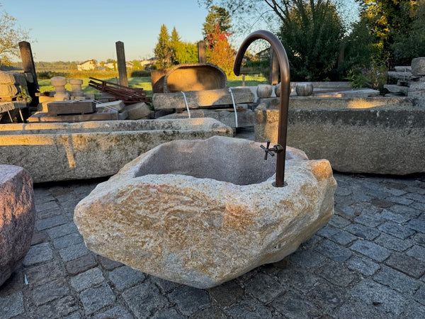 Findlingsbrunnen mit rostfarbenen Stellen