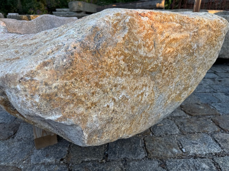 Findlingsbrunnen mit rostfarbenen Stellen