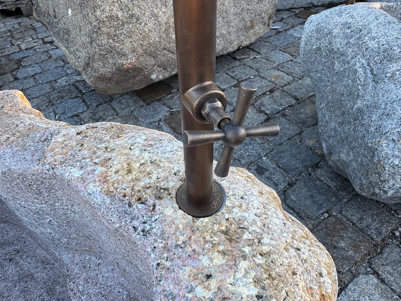 Findlingsbrunnen mit rostfarbenen Stellen