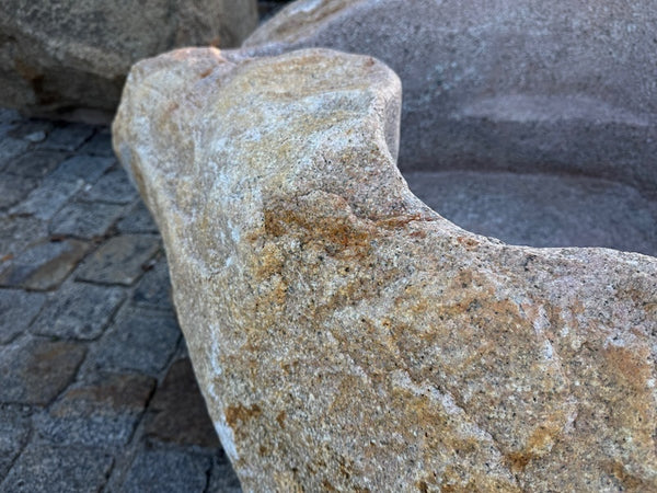 Findlingsbrunnen mit rostfarbenen Stellen