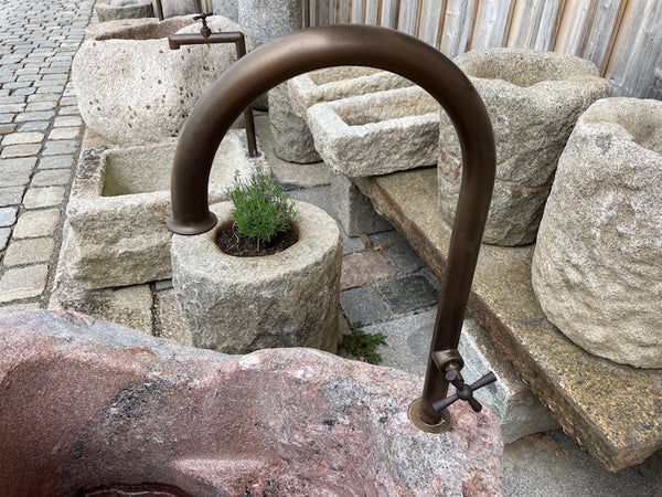Kleiner Findlingsbrunnen aus rotem Granit Messinghahn
