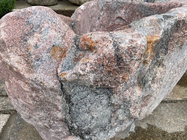 Findlingsbrunnen mit roter Oberfläche