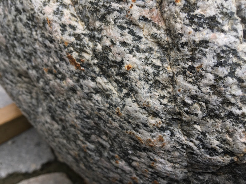 Kleiner Findlingsbrunnen mit farblichen Einschlüssen Oberfläche