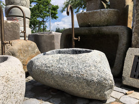 Kleiner Findlingsbrunnen mit farblichen Einschlüssen.