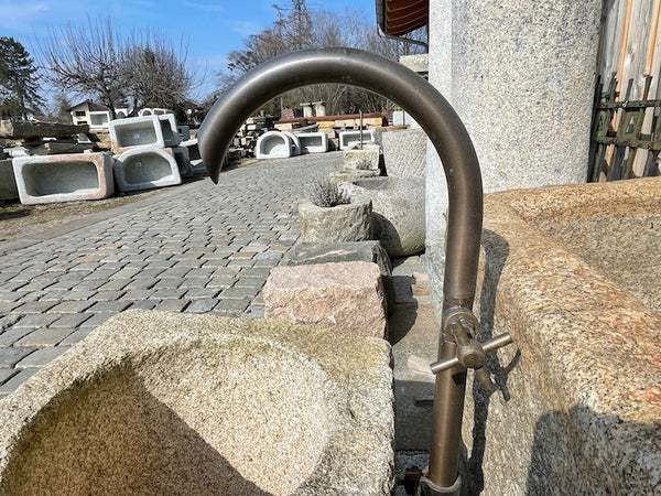 Alter Granitbrunnen mit Einlauf