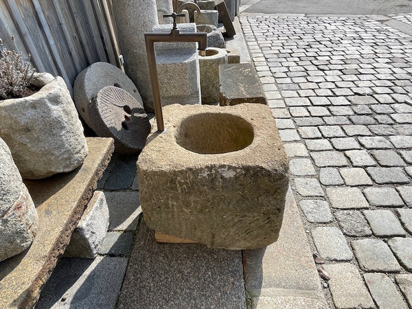 Alter Brunnen aus Sandstein mit Wassereinlauf