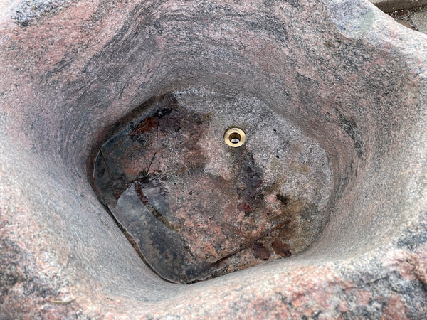 Findlingsbrunnnen rosa mit schwarzen Einschlüssen