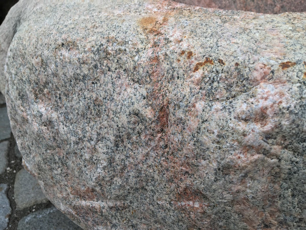 Findlingsbrunnen in rosa mit schwarzen Schlieren