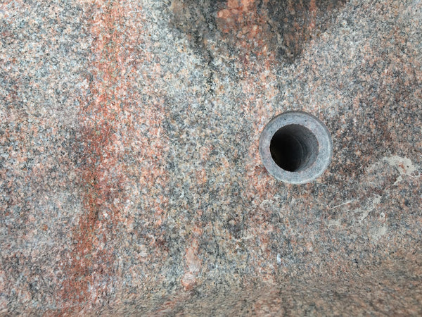 Findlingsbrunnen in rosa mit schwarzen Schlieren