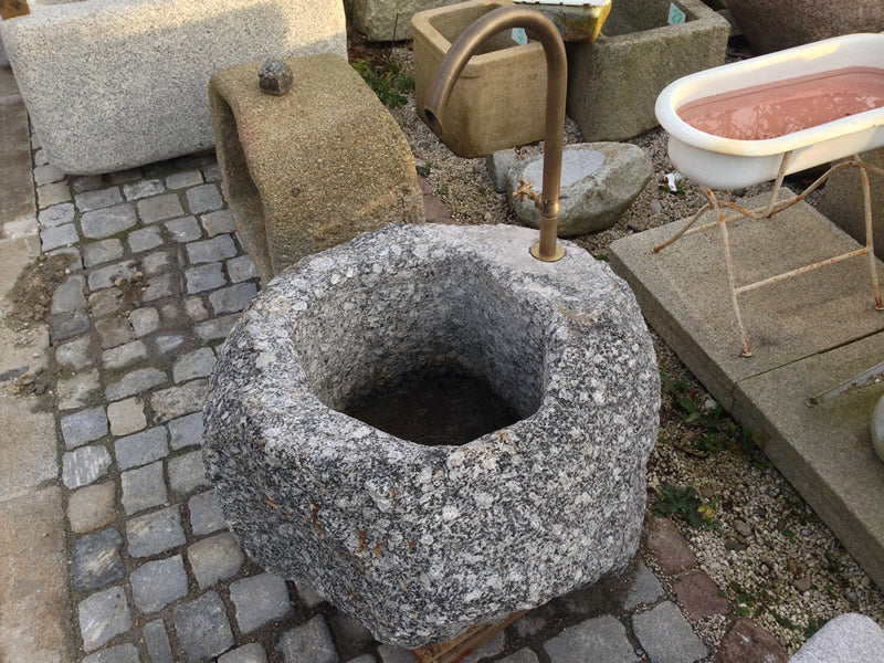 Findlingsbrunnen mit Natur Oberfläche grau