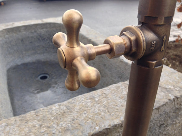 Steinbrunnen mit Wassereinlauf und Handrad